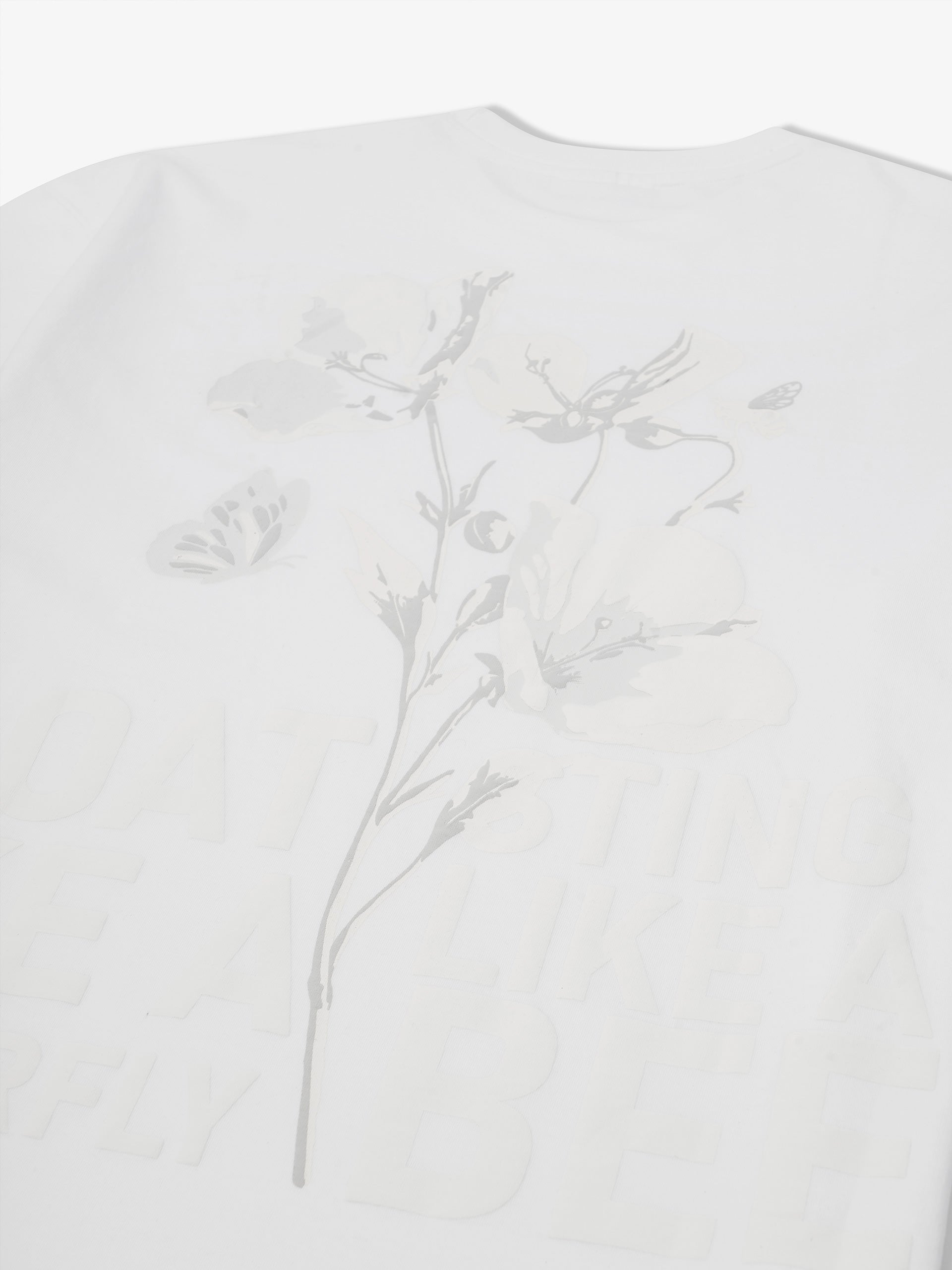 White t-shirt back print close up showing floral butterfly and bee graphic