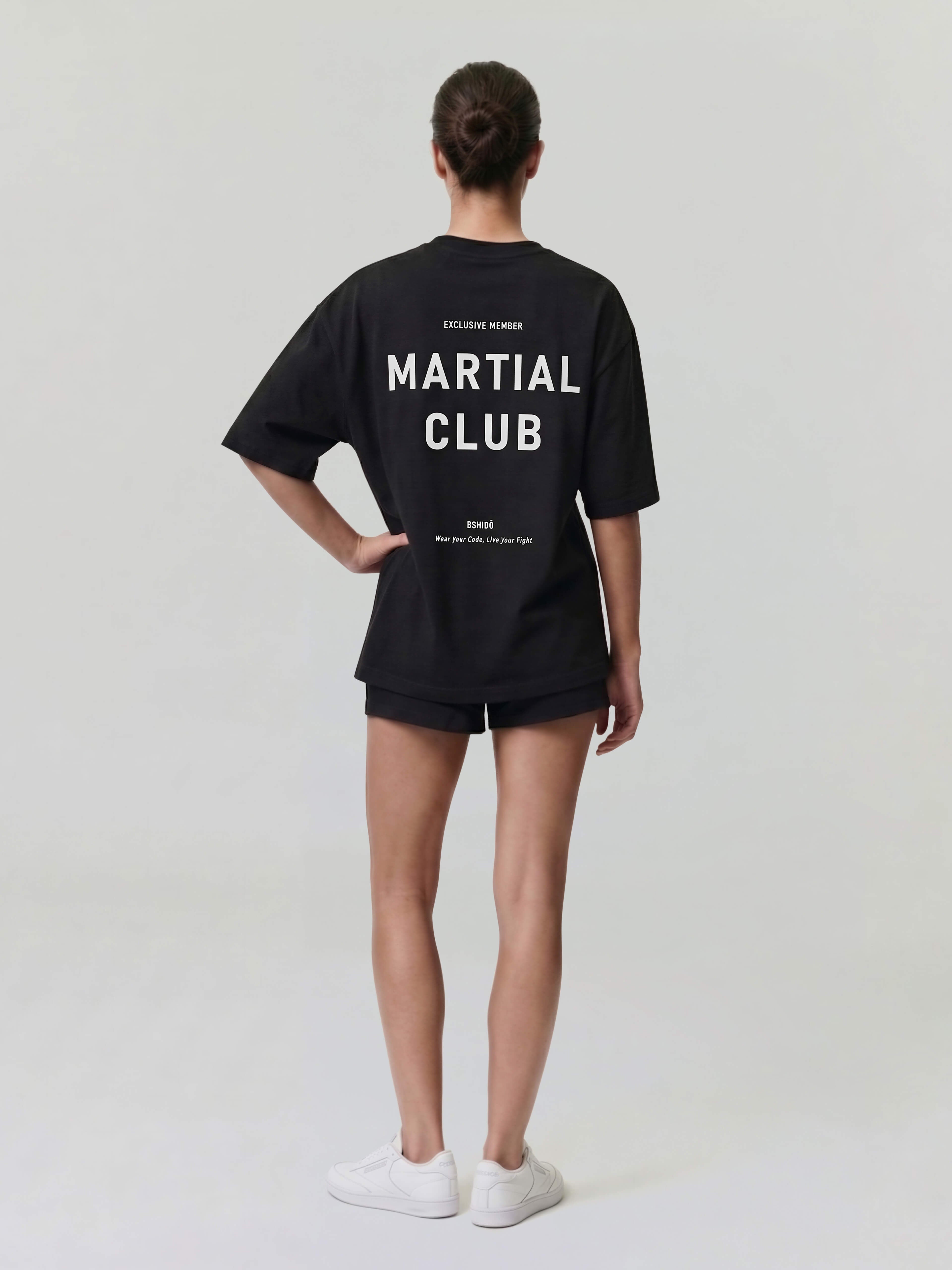 Female model wearing black oversized Bshido t-shirt back full body view with “Martial Club” print