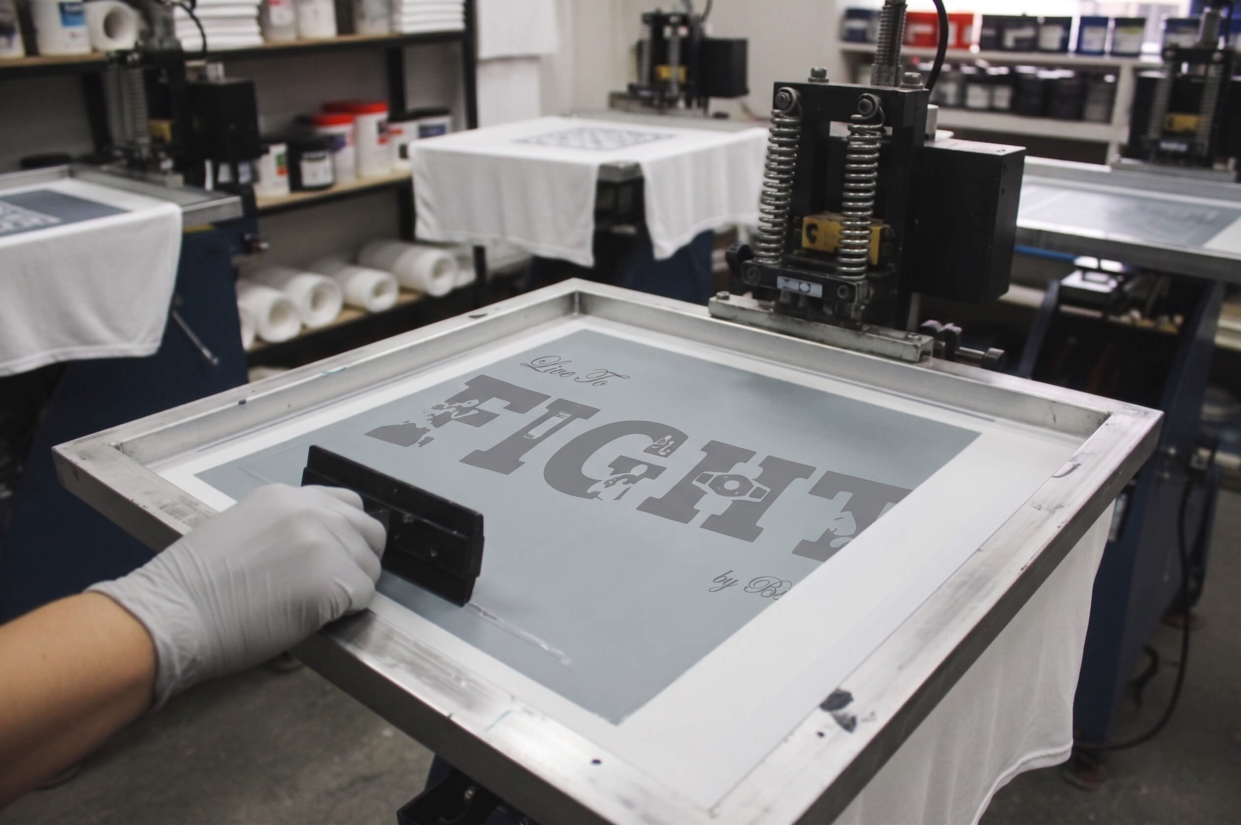 Screen printing process with a person applying ink to a screen.