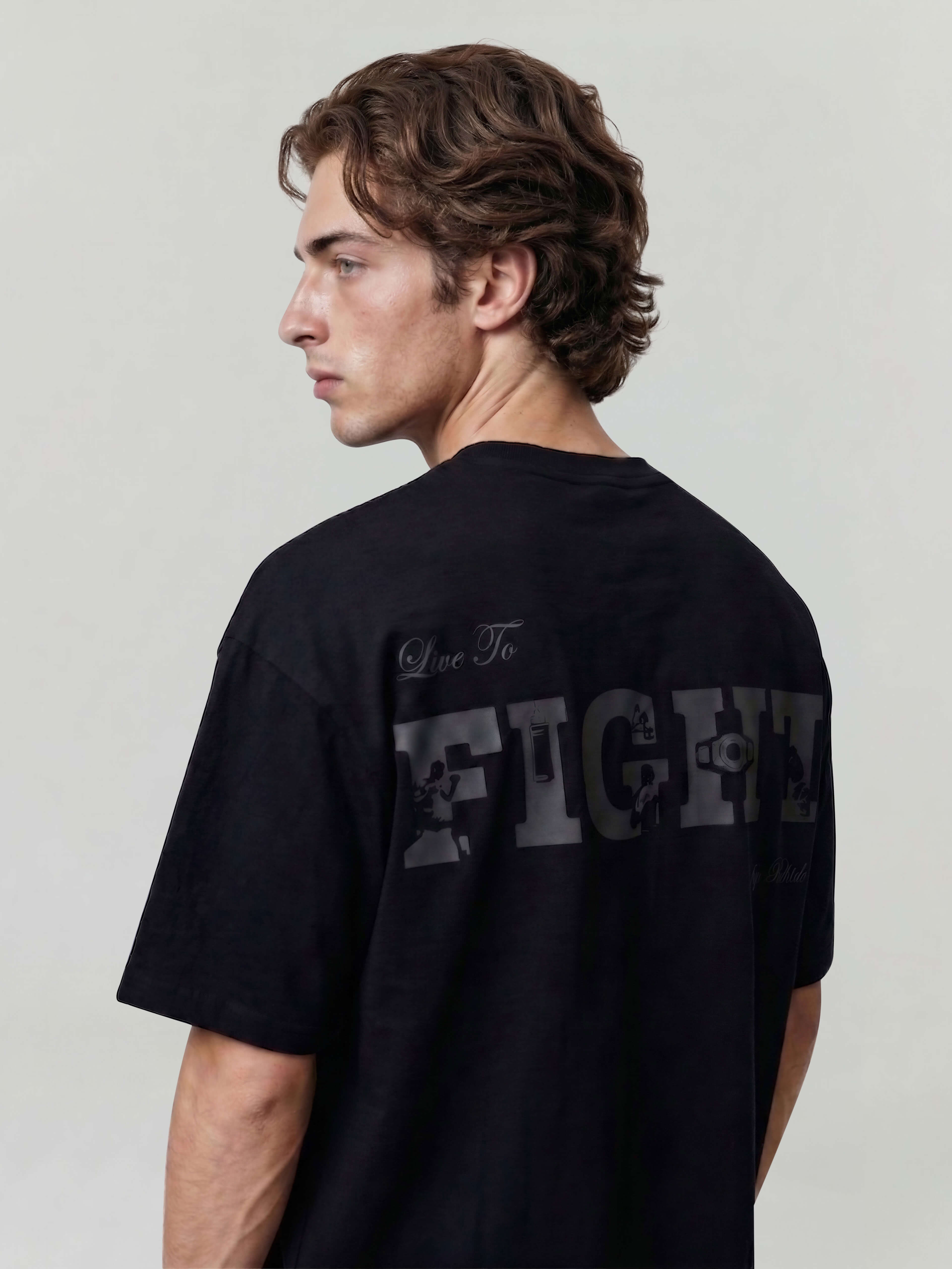 Black oversized Bshido t-shirt back view angled, featuring “Live To Fight” graphic print