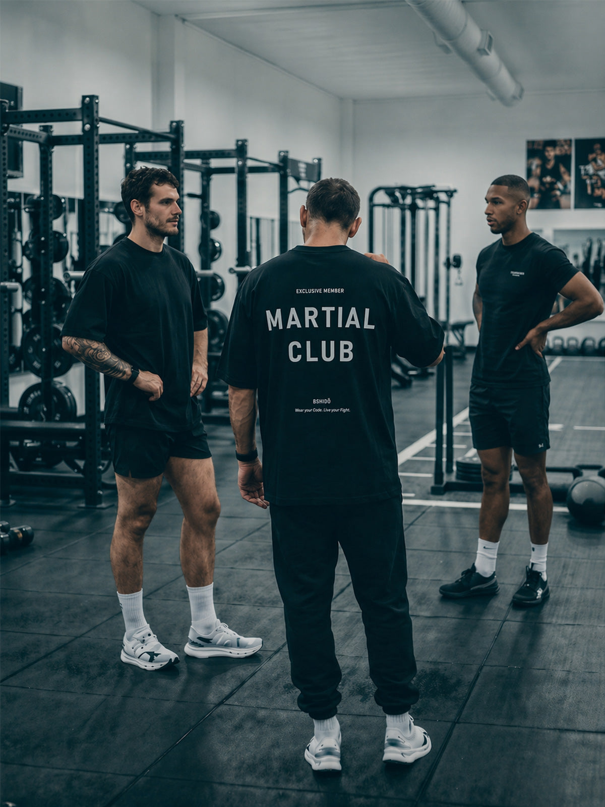 Group of athletes in gym wearing black Bshido t-shirts, featuring “Martial Club” back print during training session