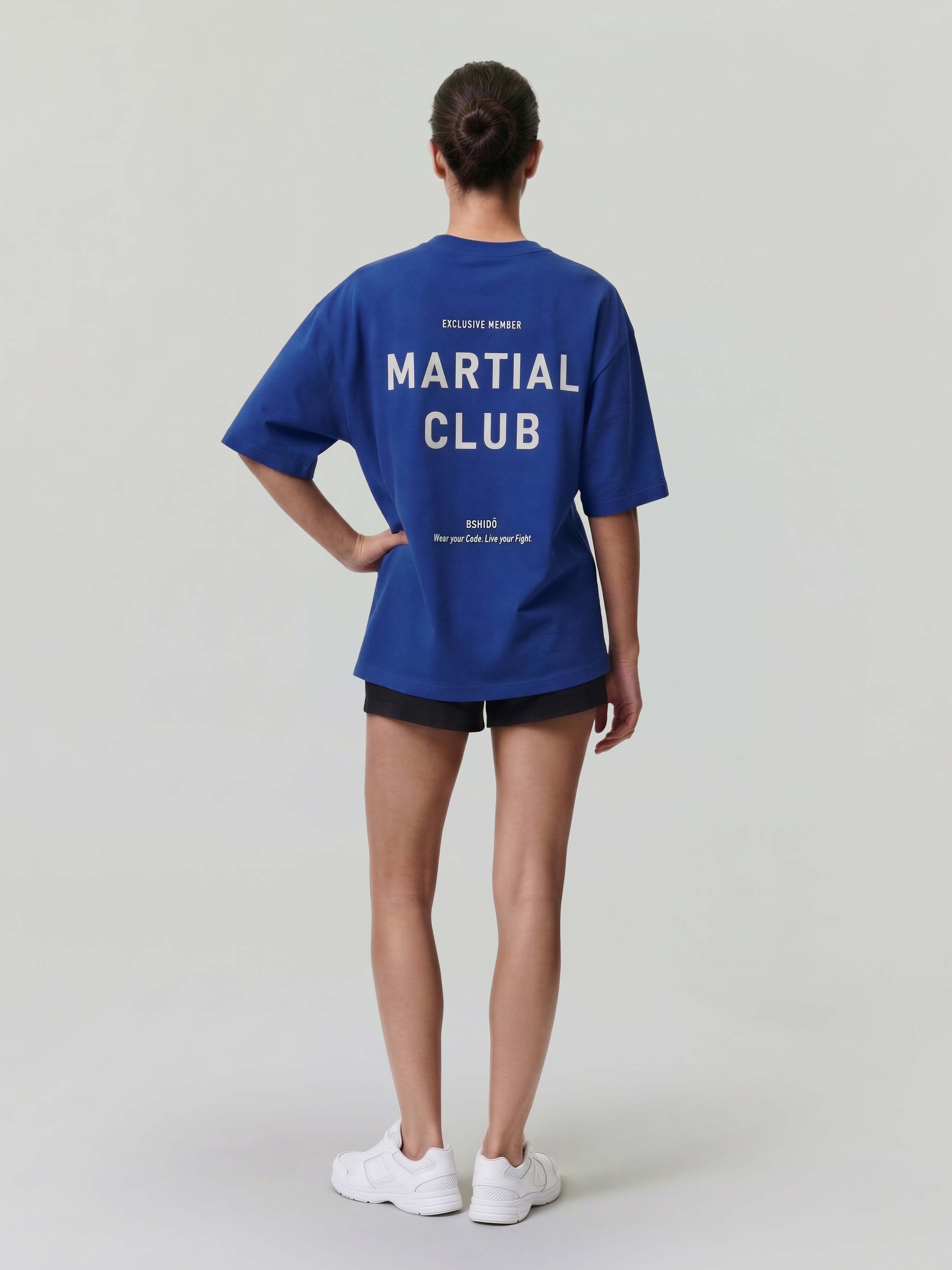 Female model wearing blue oversized Bshido t-shirt back full body view with “Martial Club” print