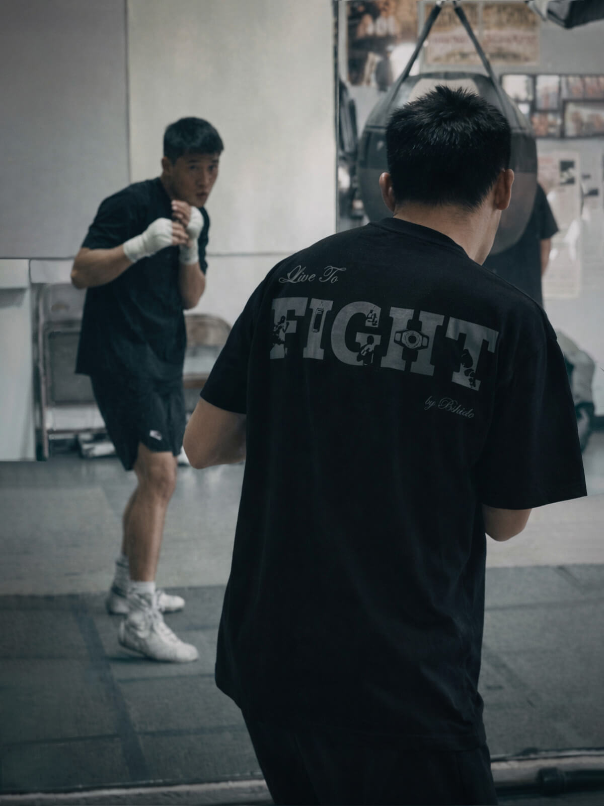 person shadow boxing in a gym, wearing a ‘Live to Fight’ Bshidō t-shirt.